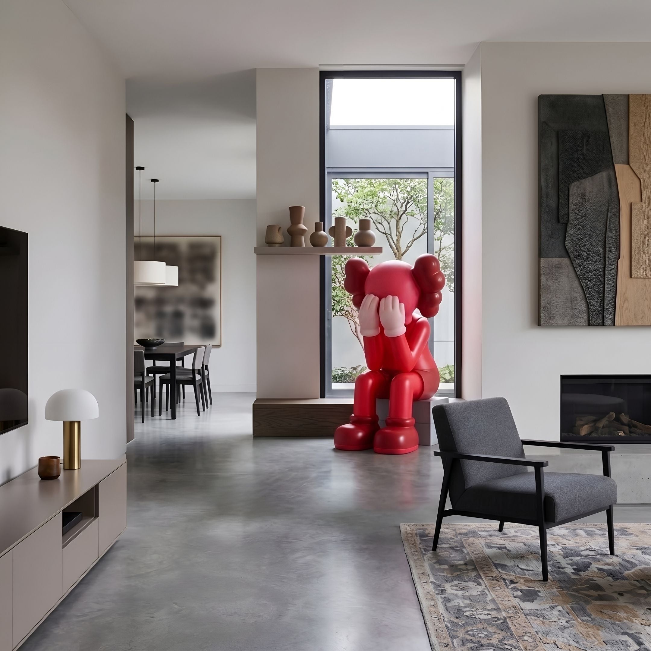 Blush Ruby Iconify Melancholy Sitting Sculpture, 163cm, seated in a living room beside a dark armchair, fireplace, and wall art.