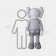 The Sofy Grey Iconify Standing Sculpture from Giant Sculptures, standing 168 cm tall, exudes artistic charm. Next to it stands a simpler outlined human figure at 160 cm. The sculptures large gloves, round pants, and distinctive cross-eye markings add a contemporary accent to the scene.