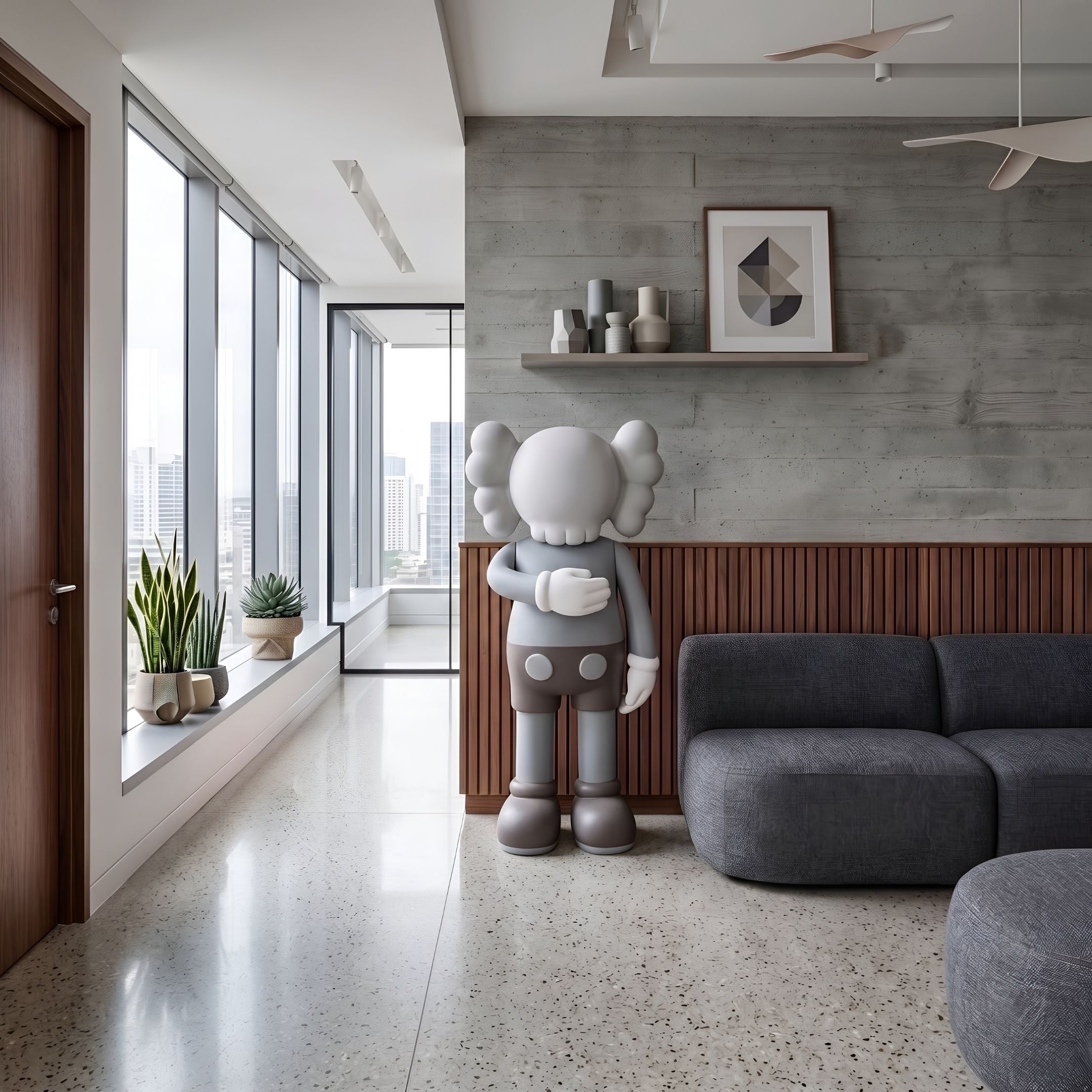 Soft Grey Iconify I Dance Sculpture, 170cm, standing figure with rounded ears in a living room beside a grey sofa and concrete wall shelf.
