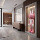 Coral Pink Iconify Rabbit Sculpture, 170cm, in a wall niche with concealed lighting, beside abstract wall art and a wooden sideboard in a modern hallway.