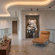 Soft Grey Iconify Family Sculpture (180cm) by Giant Sculptures, displayed in a wall niche with a leather chaise nearby in a modern hallway setting.