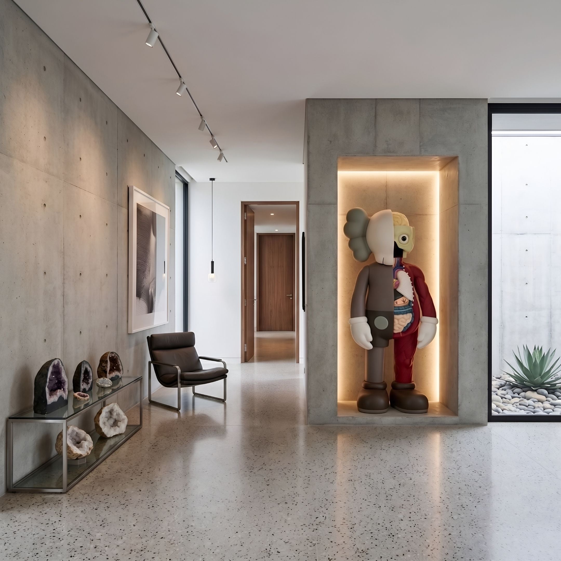 Hazelnut Brown Iconify Anatomy Sculpture, 187cm, displayed in a lit wall niche in a hallway with a leather armchair and concrete walls.