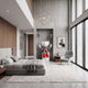 Lustrous Red Iconify Mime Sitting Sculpture, 195cm, in a bedroom on a white cube base with striped balloons beside a grey chair and concrete wall.