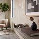 Hazelnut Brown Iconify Floating Bath Figure, 20cm, lying on a concrete shelf with white gloves and dark shorts, near a vase and framed wall art.