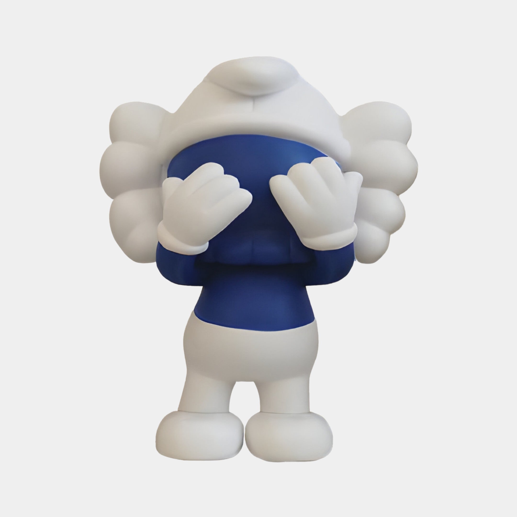 The Deep Blue Iconify Peekaboo Figure by Giant Sculptures features a stylized, whimsical character with a cloud-like head covering its face. This 20cm figure in white pants is a graceful and intriguing decorative piece for modern interiors, set against a plain white background.