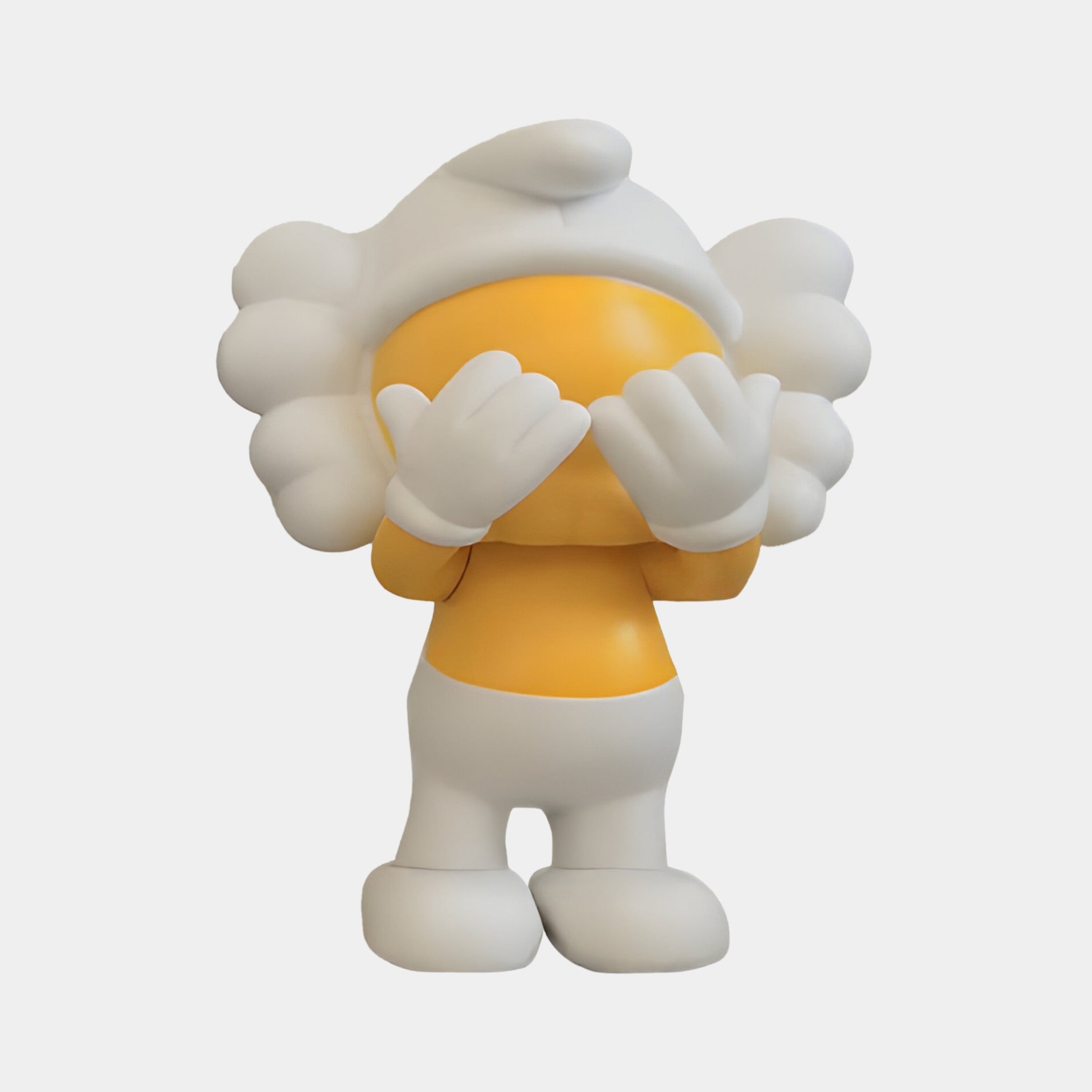 A cute character with a round orange face and fluffy white hair hides its eyes with white-gloved hands in the Giant Sculptures Yellow Iconify Peekaboo Figure, styled at 20cm with a white hat and shoes against a plain background.