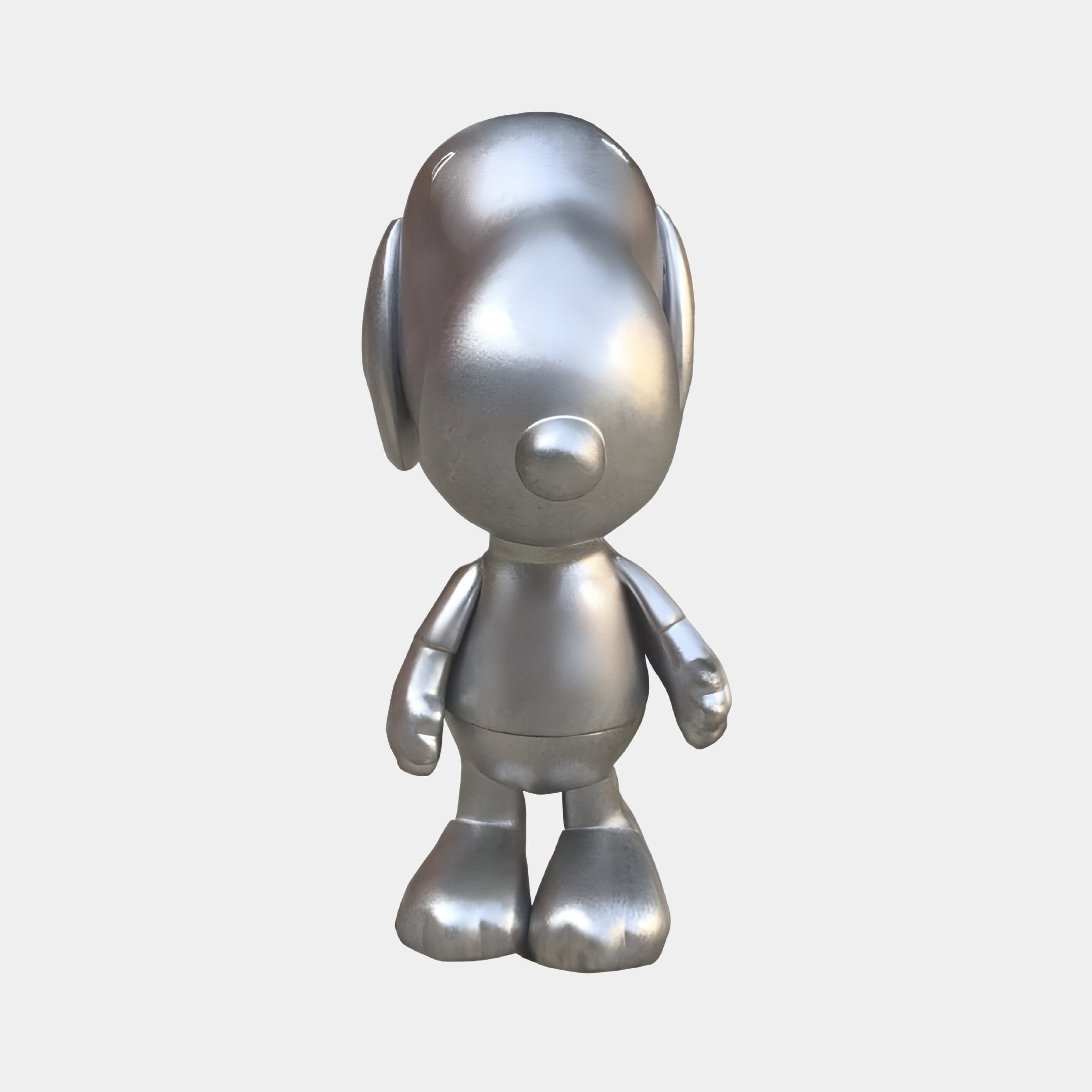 The Titanium Slate Iconify Puppy Figure by Giant Sculptures is a modern 20cm metallic silver cartoon dog, featuring a minimalist design with an oval head, floppy ears, and rounded features that enhance industrial interiors, set against a plain white background.