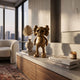 Antique Brushed Gold Iconify Scar Figure, 20cm, displayed on a concrete console beside books and a vase in a modern living room with city-view windows.