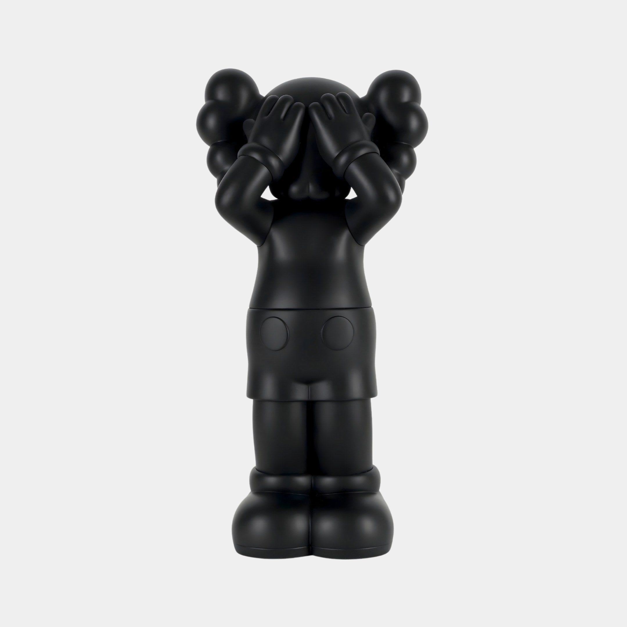 The Giant Sculptures Midnight Black Iconify Silent Cry Figure - 20cm is a modern art piece featuring a cartoonish character. It has round ears, big shoes, and hands covering its eyes. The statues smooth surface and exaggerated proportions make it a striking minimalist decorative accent.