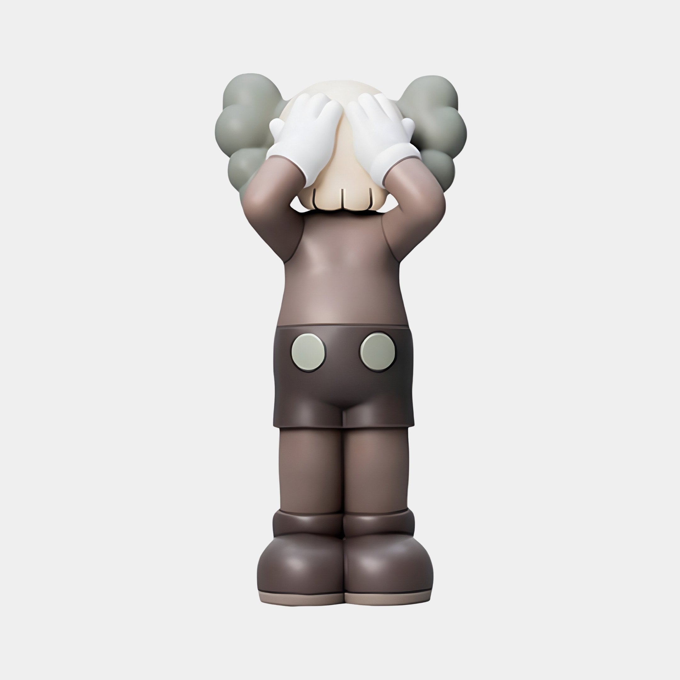 The Hazelnut Brown Iconify Silent Cry Figure by Giant Sculptures, standing at 20cm, displays modern artistry with a gray-haired figurine in brown shorts and large white gloves covering its eyes. It features a cartoonish design with exaggerated elements against a plain background.