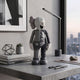 Slate Grey Iconify Anatomy Figure (20cm) by Giant Sculptures, half-solid half-anatomical design, displayed on a concrete desk beside books, a lamp, and a city view.