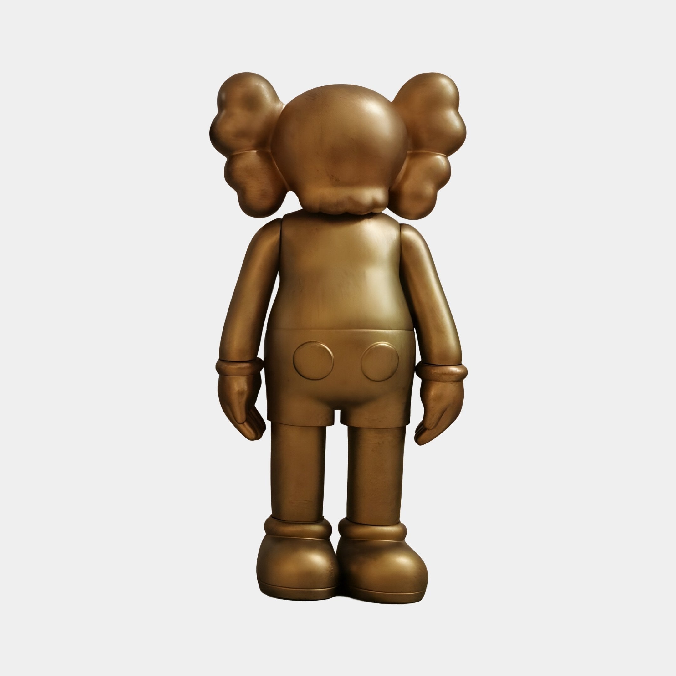 The Antique Brushed Gold Iconify Standing Figure by Giant Sculptures is a 20cm bronze-colored resin piece featuring a cartoon-like design with large round ears and gloved hands. Facing away, its minimalist style and antique finish offer a modern twist on a beloved pop culture toy.