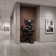 Midnight Black Iconify Family Sculpture, 200cm, matte black resin figures displayed in a gallery corridor with wood slat wall and concrete surfaces.