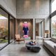 Deep Navy Blue Suit Iconify CEO Sculpture, 200cm, with pink hair and shoes, displayed on a pedestal in a modern living room with concrete walls and a leather chair.