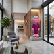 Deep Magenta Suit Iconify CEO Sculpture, 200cm, pink resin figure with textured hair on a concrete base in a modern living room hallway.