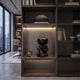 Obsidian Black Iconify Hollow Figure (23cm) seated in a lit display shelf niche, shown within a modern study featuring bookshelves and a city-view window.