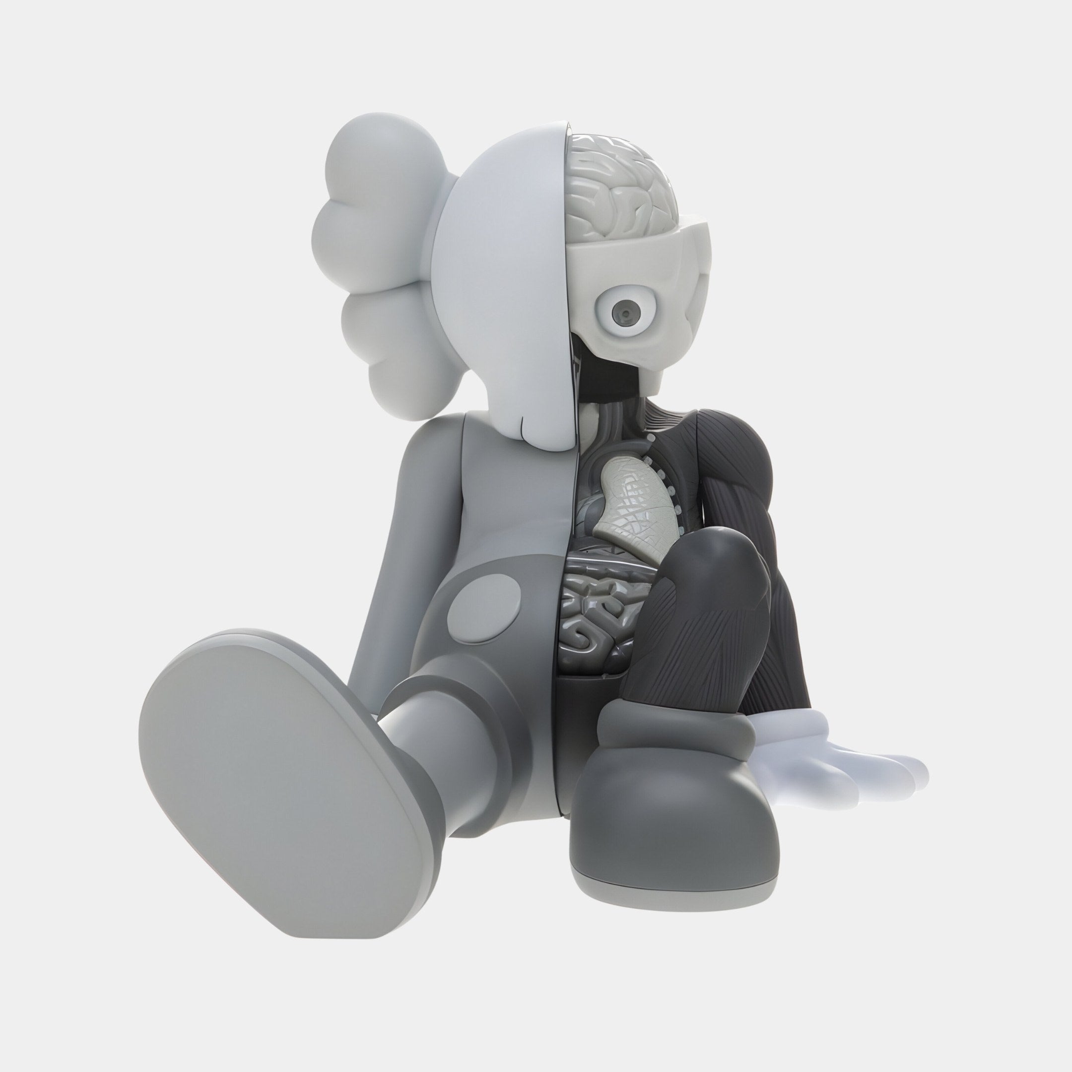 The Slate Grey Iconify Anatomy Figure by Giant Sculptures features legs outstretched, one hand on the floor, showcasing a detailed anatomical cross-section of brain, bones, and organs in a minimalist monochrome style reminiscent of pop-art collectibles. This resin sculpture measures 23cm.