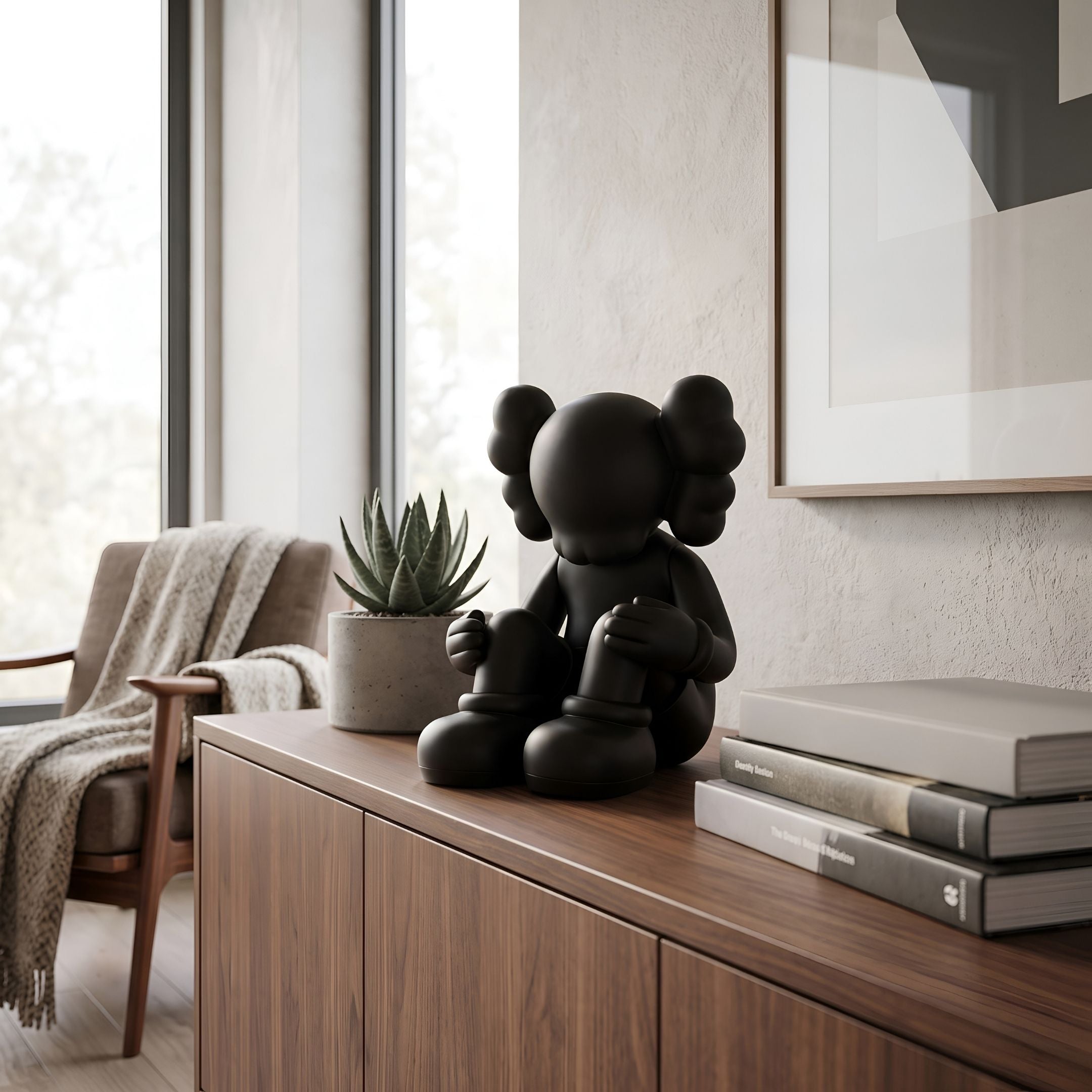 Obsidian Black Iconify Silent Figure, 25cm, seated matte black polyvinyl sculpture on a walnut sideboard beside books and a succulent.