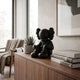 Obsidian Black Iconify Silent Figure, 25cm, seated matte black polyvinyl sculpture on a walnut sideboard beside books and a succulent.