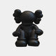 An Obsidian Black Iconify Silent Figure by Giant Sculptures, 25cm tall, crafted in a monochrome palette with large round ears and a featureless face, sits cartoon-like on the ground. Made from resin, it is set against a plain white background.
