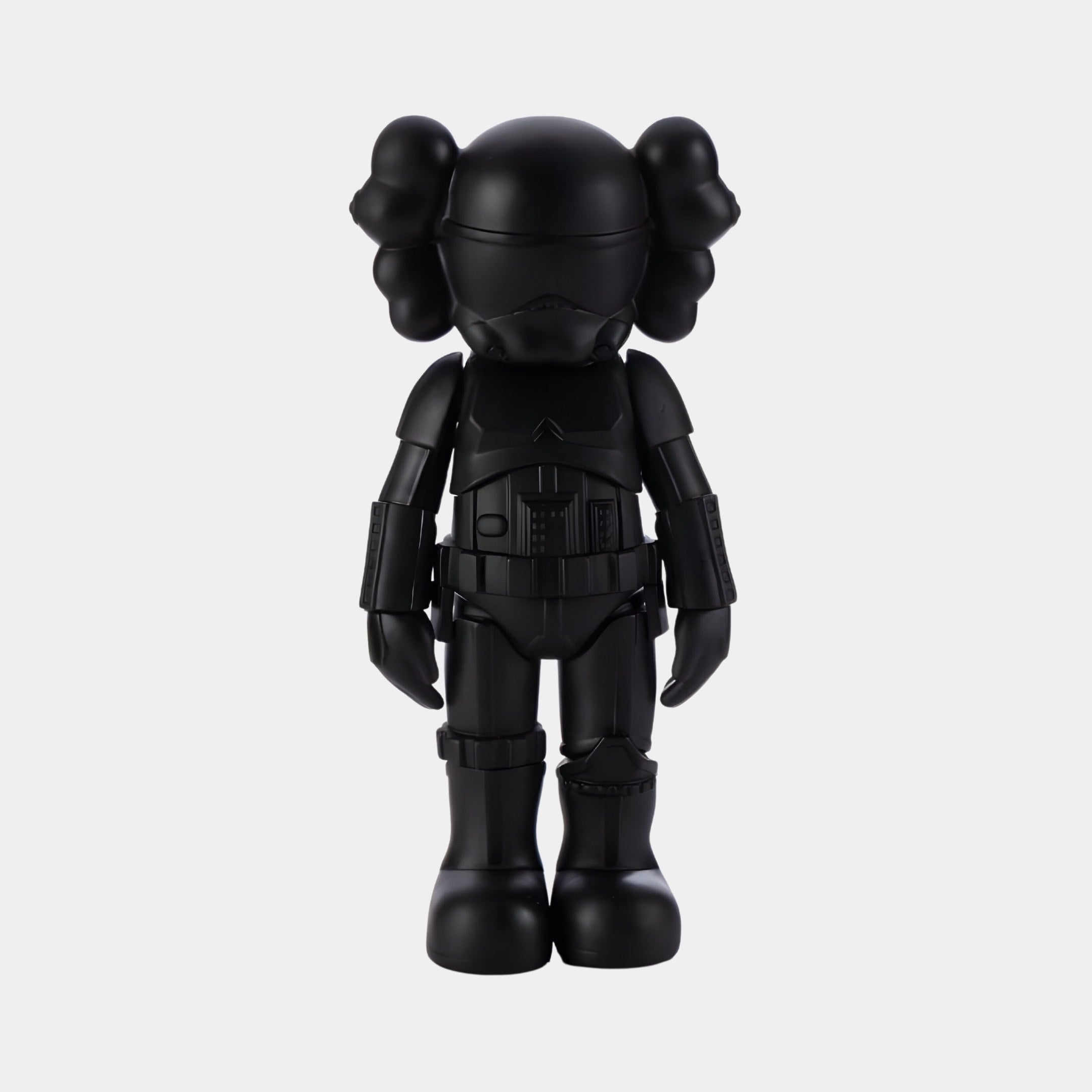 Introducing the Midnight Black Iconify Enforcer Figure by Giant Sculptures—a 26cm resin figure echoing contemporary interiors. This black vinyl piece sports a cartoonish character with crossed bones on its head, exaggerated features, and a decorative suit, set against a plain white backdrop.