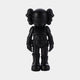 Introducing the Midnight Black Iconify Enforcer Figure by Giant Sculptures—a 26cm resin figure echoing contemporary interiors. This black vinyl piece sports a cartoonish character with crossed bones on its head, exaggerated features, and a decorative suit, set against a plain white backdrop.