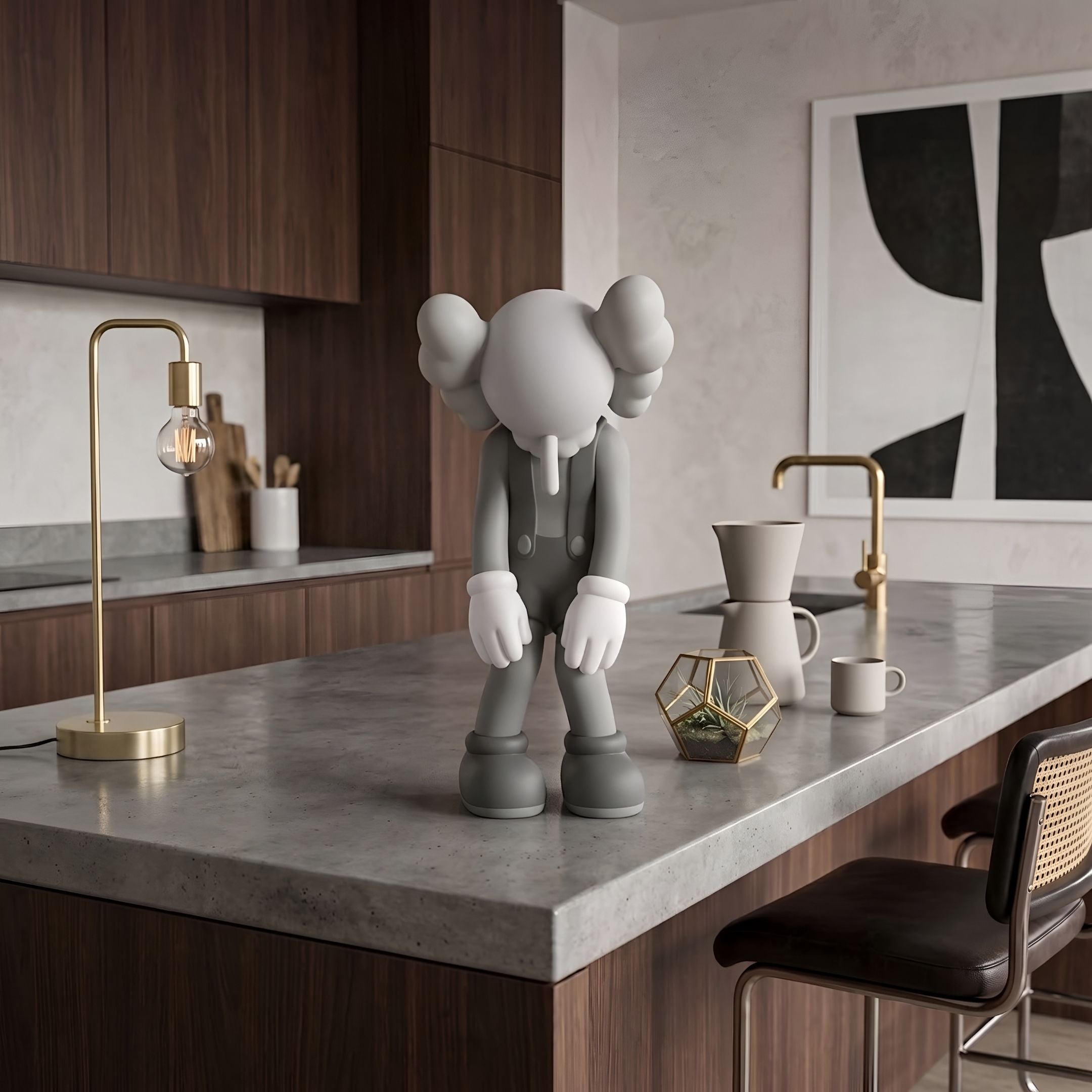 Soft Grey Iconify Burden Figure, 28cm, standing on a kitchen island countertop with wood cabinetry, brass fixtures, and abstract wall art in the background.