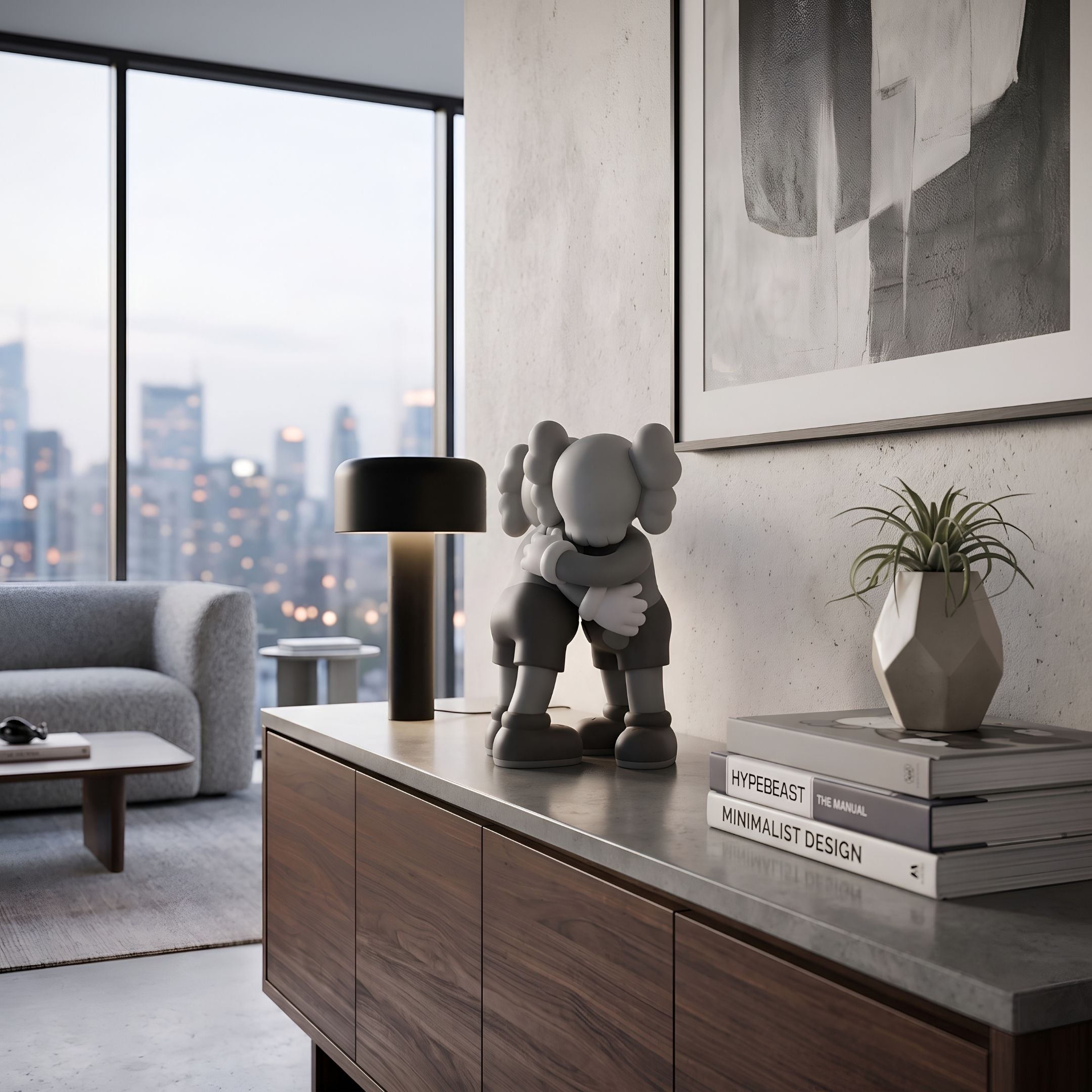 Soft Grey Iconify Embrace Figure - 28cm displayed on a walnut sideboard beside books and a plant, with a city-view living room in the background.