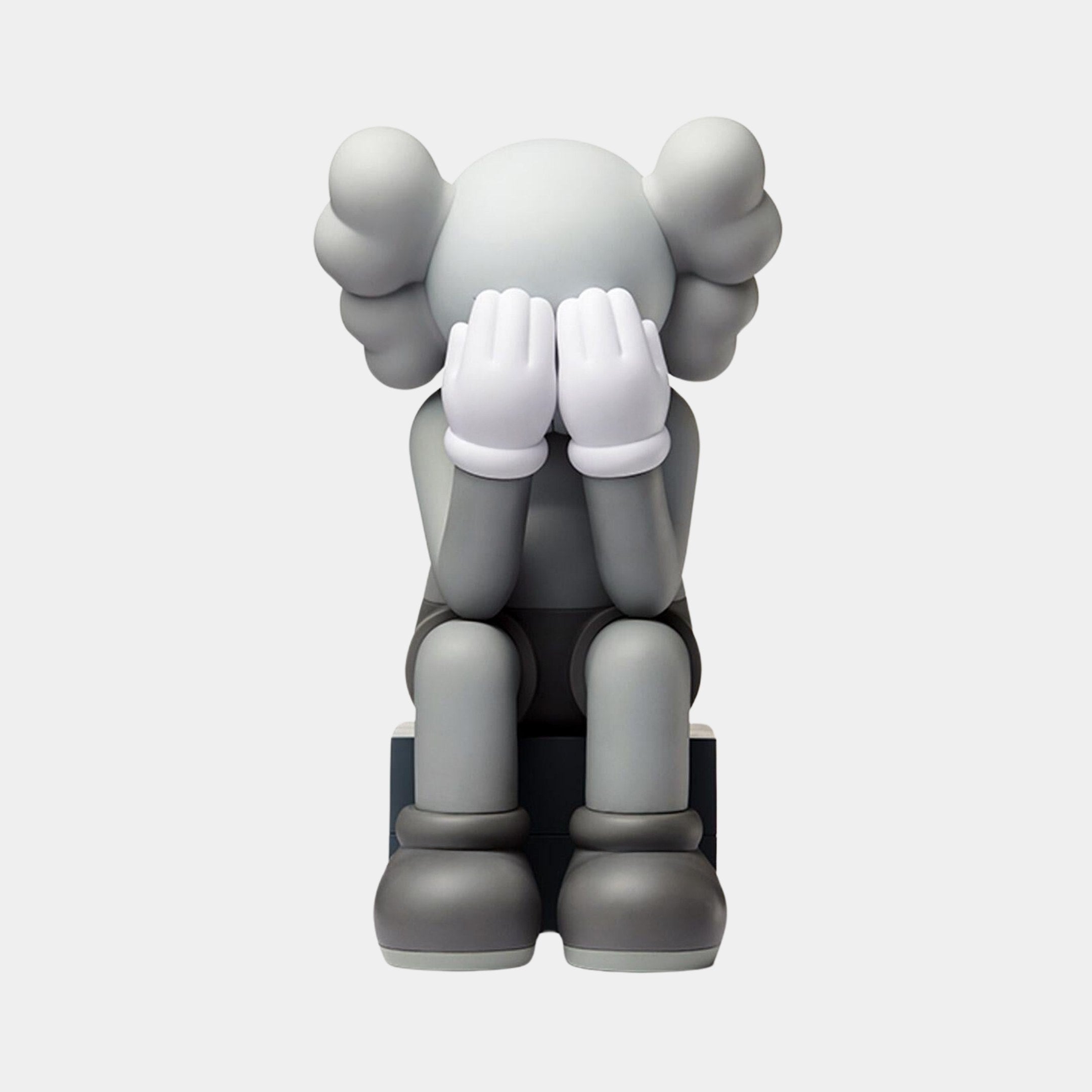 The Slate Grey Iconify Melancholy Sitting Figure by Giant Sculptures is a 28cm resin piece featuring a figure with puffy ears and white gloves, resting on a block and hiding its face in its hands, conveying sadness or contemplation.