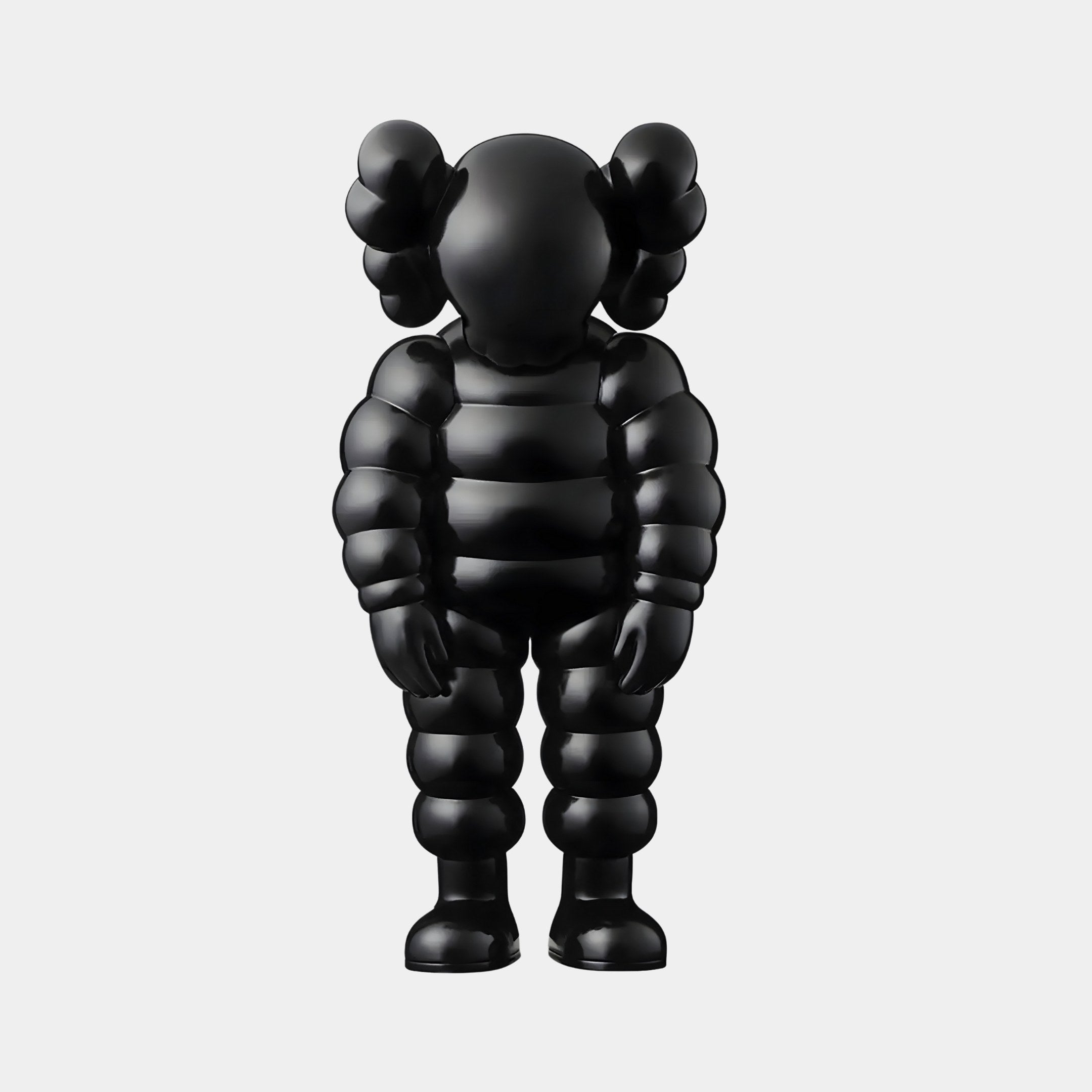 The 28cm Midnight Black Iconify Rollo Figure by Giant Sculptures stands against a plain background, showcasing an abstract, segmented body and limbs. Its head features ear-like shapes enhancing its modern design, while the smooth surface gleams with contemporary artistry.