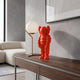 Fiery Orange Iconify Rollo Figure, 28cm, on a wooden console table beside a globe lamp in a modern living room with a beige sofa.