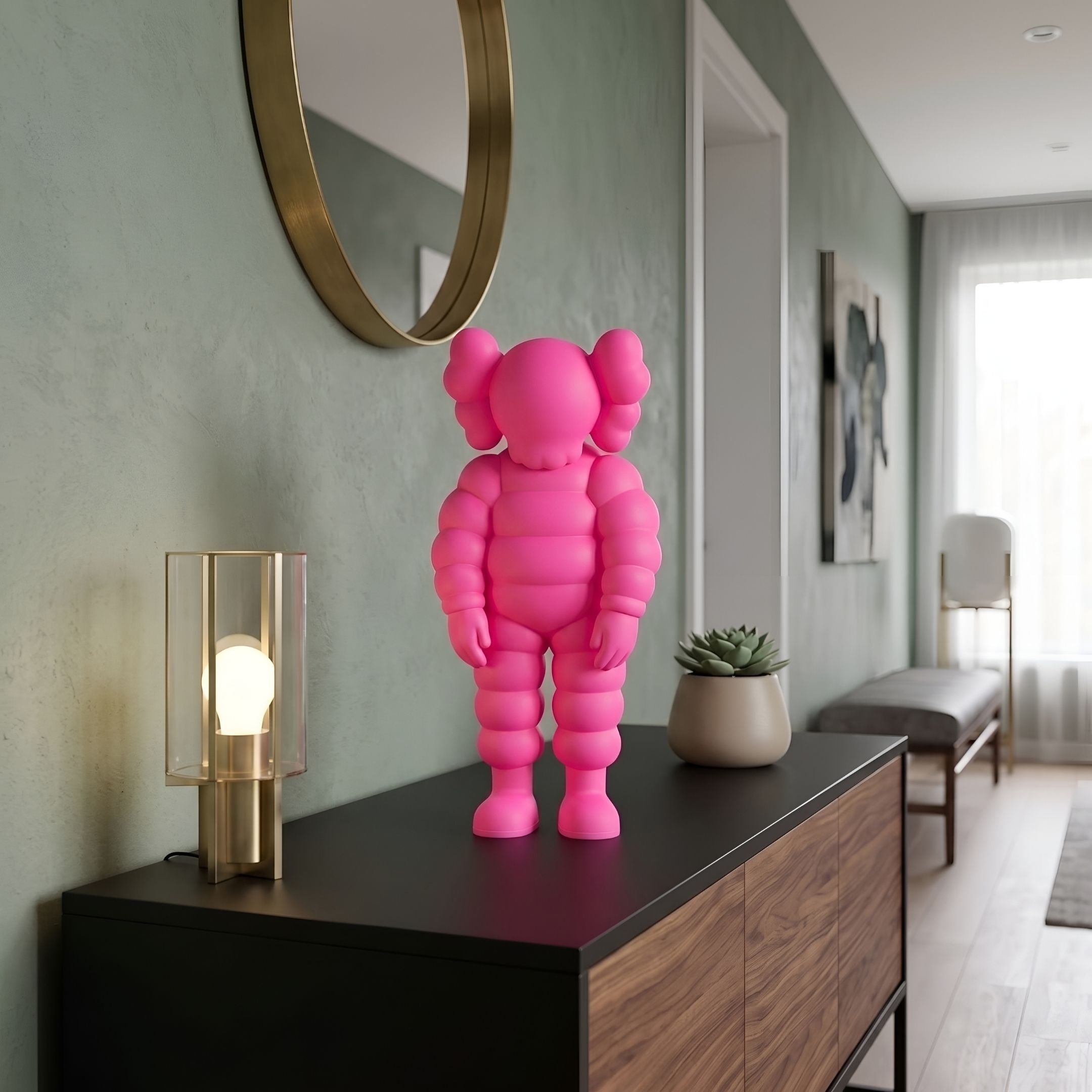 Electric Pink Iconify Rollo Figure, 28cm, displayed on a black sideboard beneath a round brass mirror in a hallway setting.