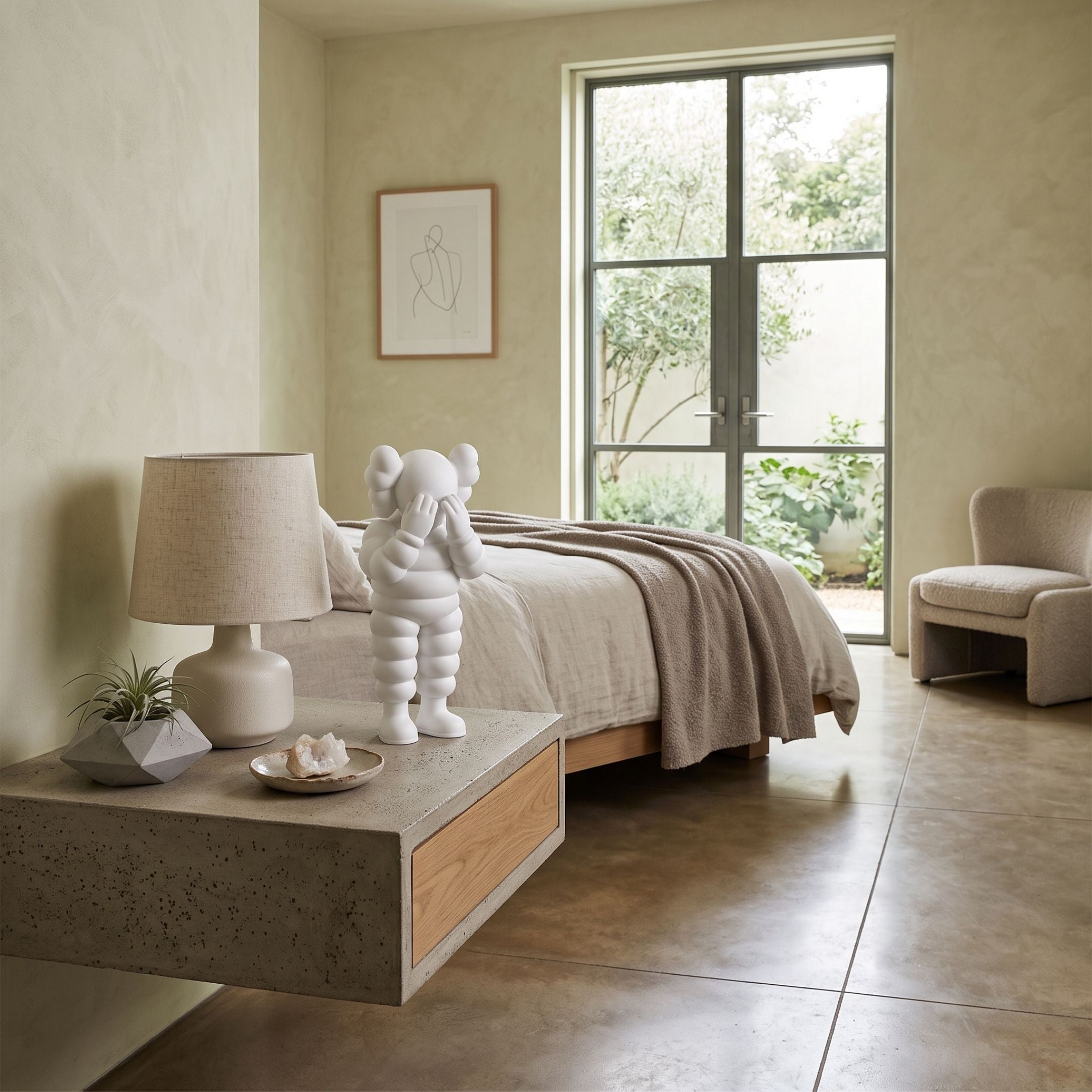 Cloud White Iconify Rollo Figure - 28cm displayed on a bedroom nightstand beside a linen bed and lamp, its padded white form standing upright.