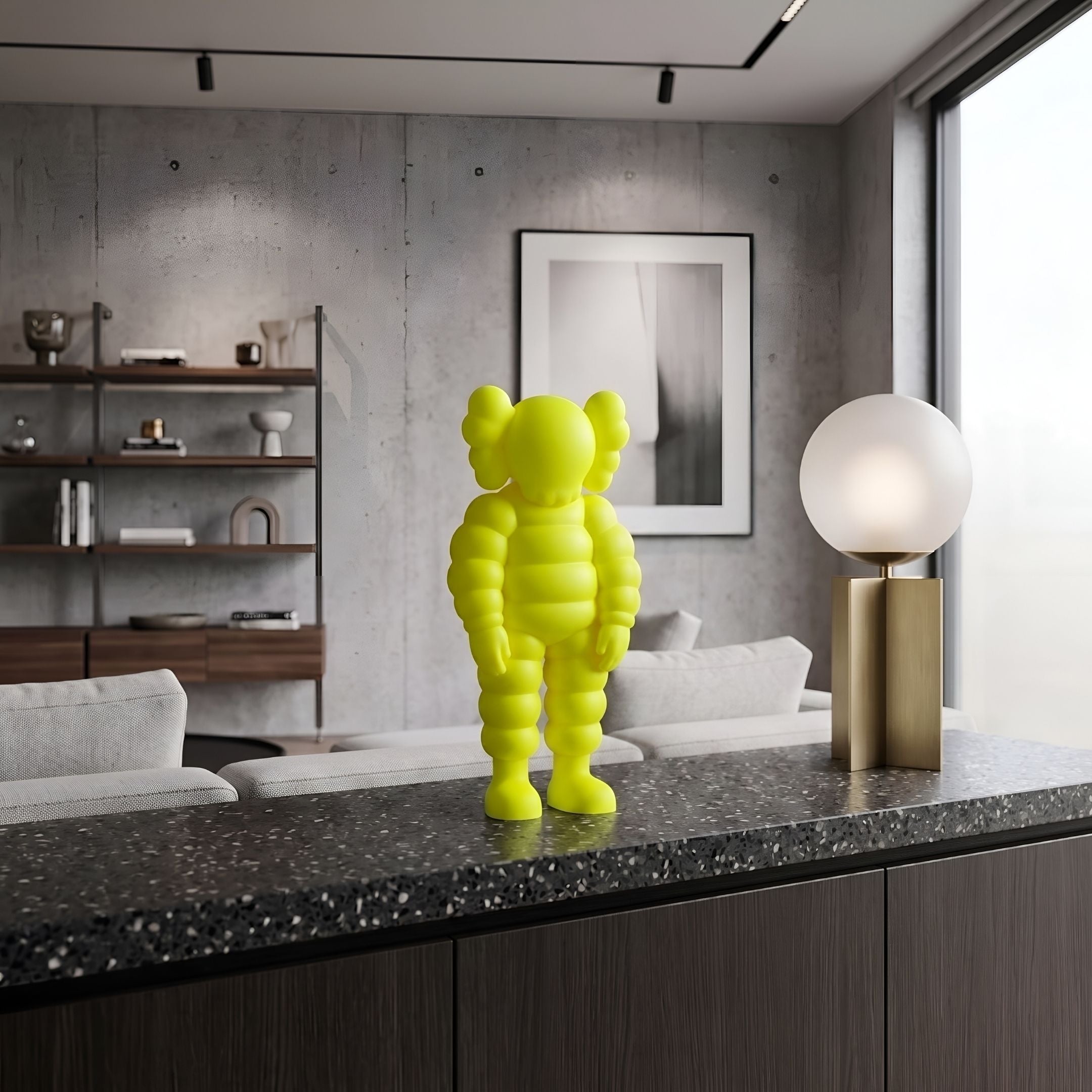 Citrus Yellow Iconify Rollo Figure (28cm) by Giant Sculptures, polyvinyl figure with round head and cloud-like ears, on a countertop beside a modern lamp and shelving.