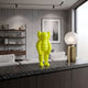 Citrus Yellow Iconify Rollo Figure (28cm) by Giant Sculptures, polyvinyl figure with round head and cloud-like ears, on a countertop beside a modern lamp and shelving.
