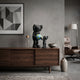 Obsidian Black Iconify Atlas Figure - 30cm, black polyvinyl sculpture of a tall and small figure holding a blue-green globe, displayed on a walnut sideboard in a living room.