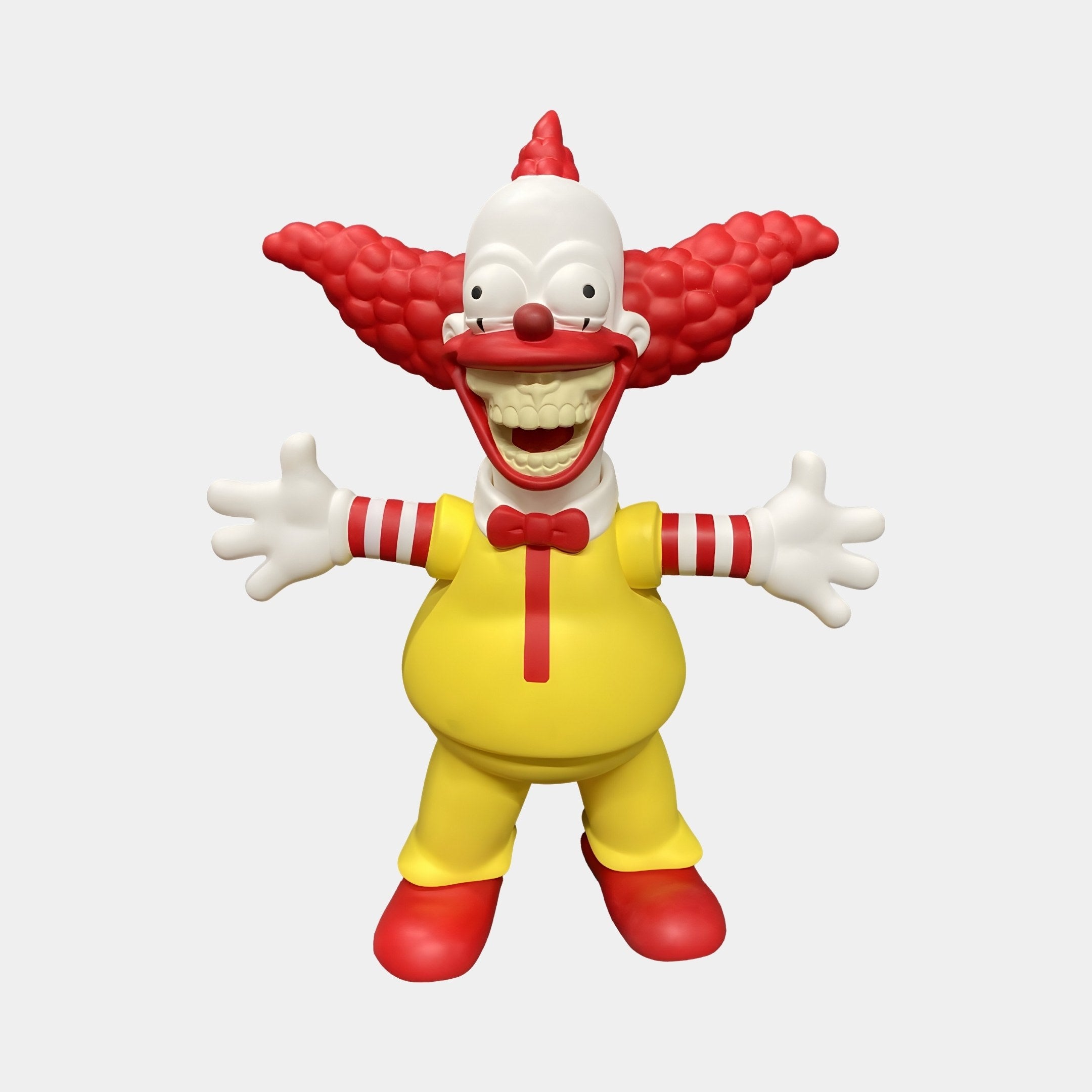 Iconify your space with the Golden Maize Yellow Chuckle Figure by Giant Sculptures. This 30cm 3D cartoon clown, with a wide grin, red curly hair, red nose, and detailed costume with red accents and shoes, adds pop-inspired art charm to contemporary interiors against its plain white backdrop.