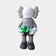 The Driftwood Grey Iconify Dollars Figure by Giant Sculptures is a 30cm stylized piece featuring a cartoon character with large round white eyes and cloud-like ears. The figure holds a small green toy, wearing shorts and boots, standing proudly against a plain background.