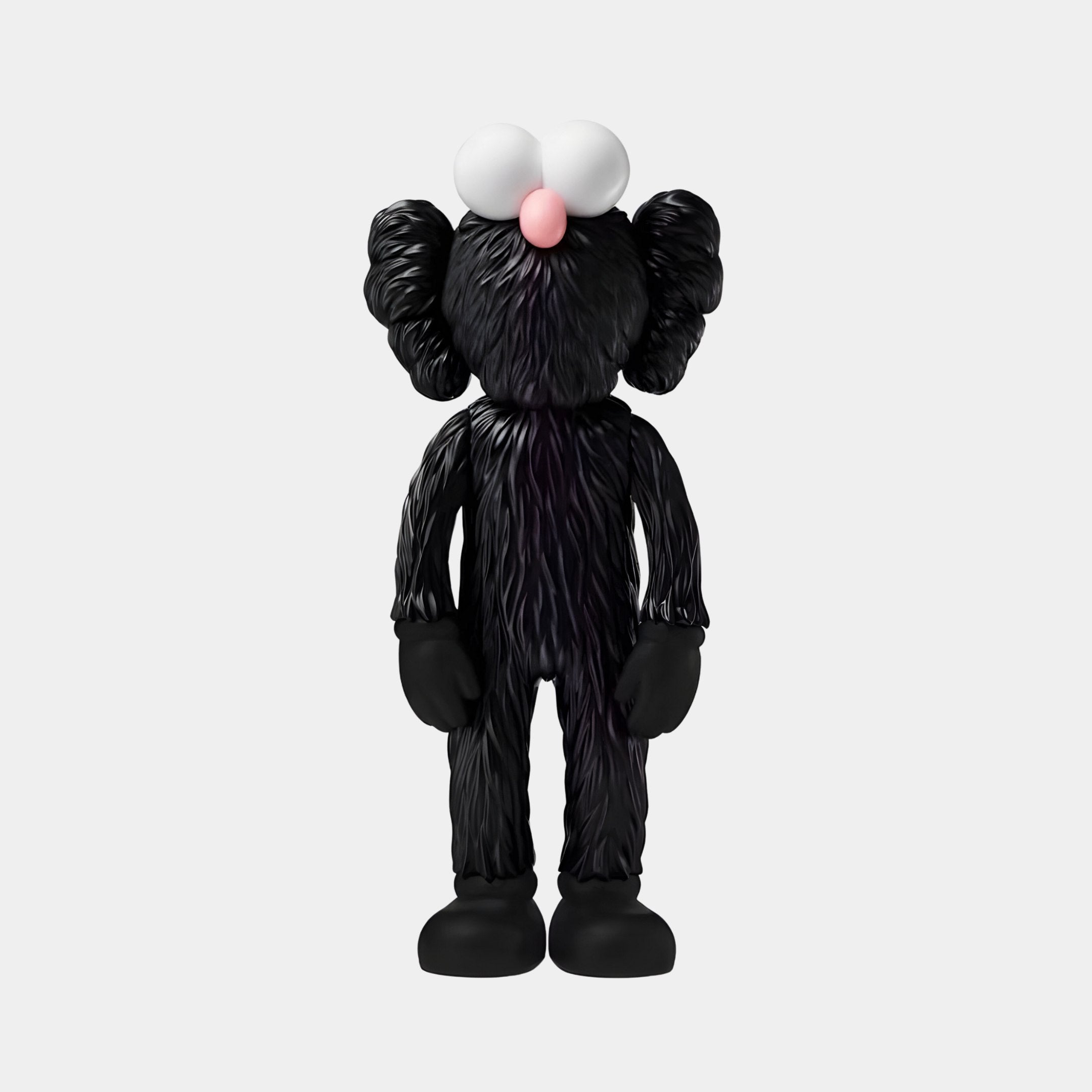 The 30cm Obsidian Black Iconify Furry Figure by Giant Sculptures, with large white eyes, a small pink nose, and oversized ears and limbs, stands on a light background. Its captivating design makes it a contemporary sculpture perfect for art collectors.