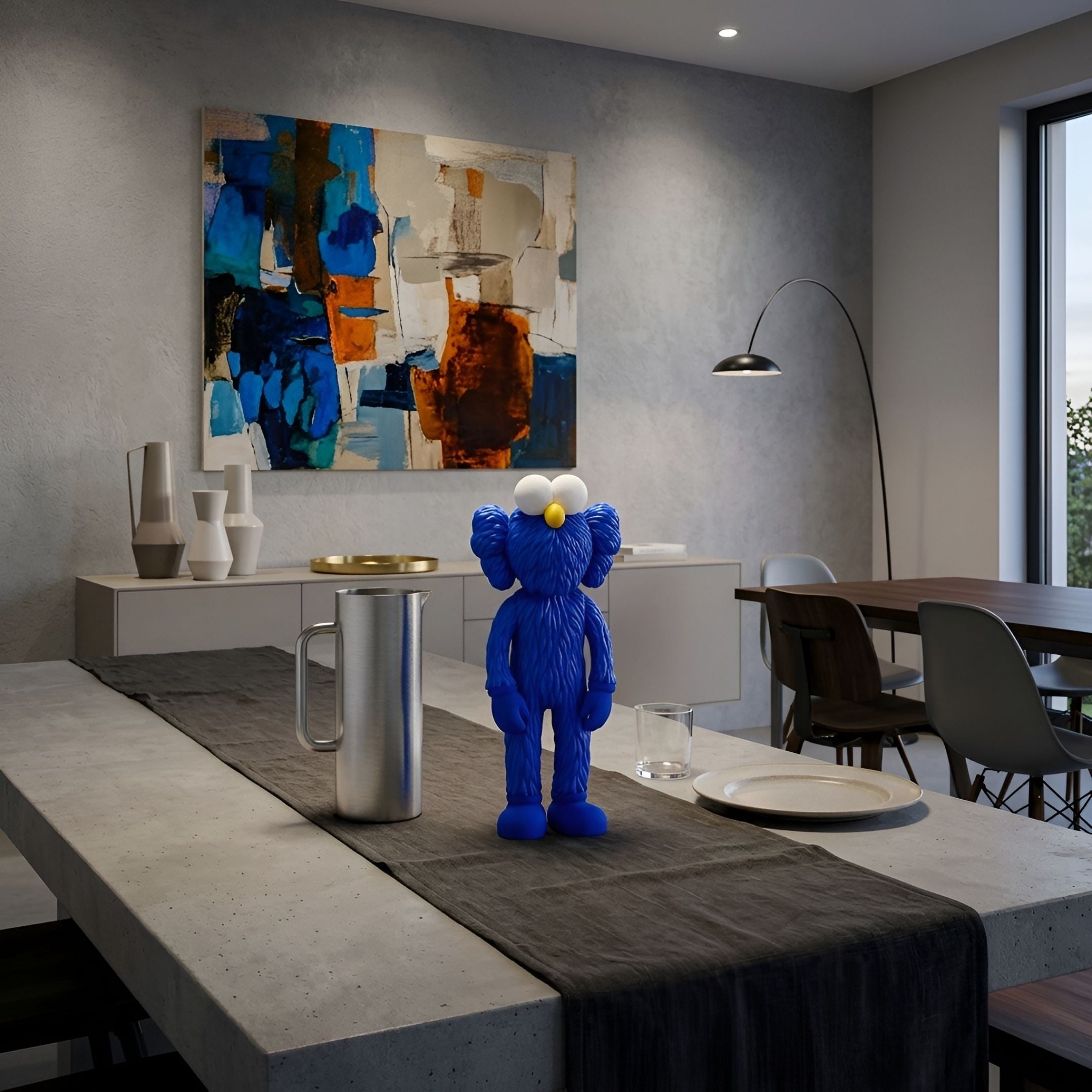 Deep Blue Iconify Furry Figure - 30cm, a blue polyvinyl collectible with white eyes and yellow nose, displayed on a dining table beside a metal pitcher and abstract wall art.