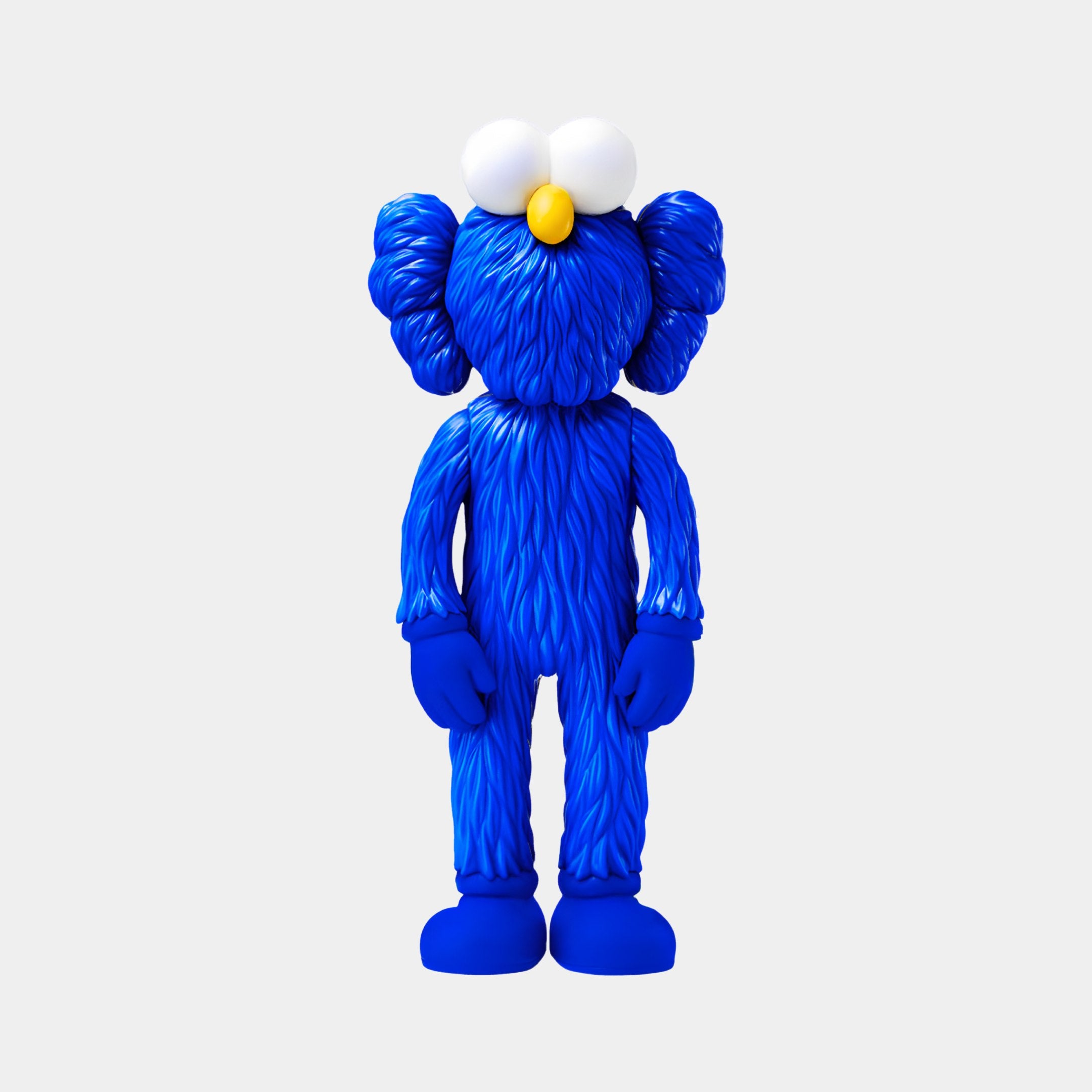 The Deep Blue Iconify Furry Figure by Giant Sculptures features a dome head, large white eyes, a yellow nose, and exaggerated hands and feet. Standing 30cm tall, its perfect for contemporary art collections and modern home decor against simple backdrops.