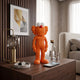 Flame Orange Iconify Furry Figure, 30cm, textured orange collectible with round white eyes, displayed on a wooden dresser beside a lamp and watch.