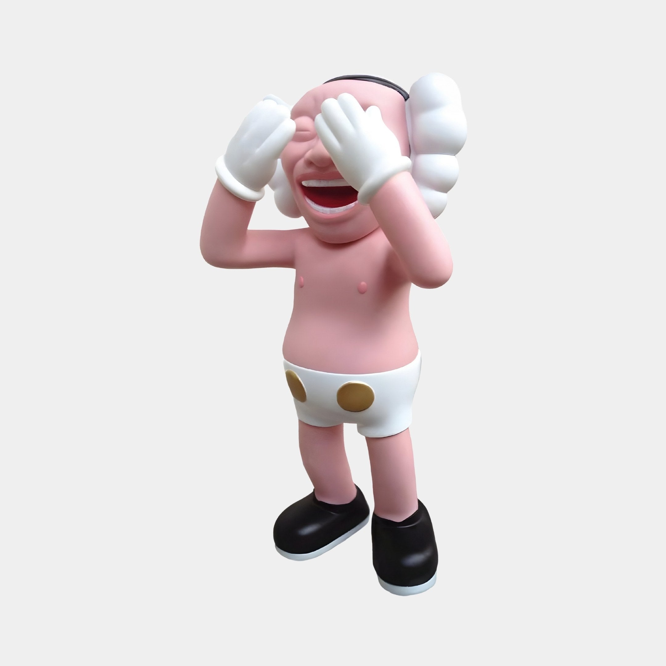 The Petal Pink Iconify Jolly Figure by Giant Sculptures is a playful 30cm sculpture in petal pink featuring white gloves and large puffy ears. It grins while covering its eyes, dressed in white shorts with brown dots and black shoes against a plain white background.