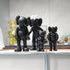 The Iconify I All-Together Figure by Giant Sculptures features four black resin sculptures with smooth, fluffy, shiny, and spiky textures. Displayed on a shelf, they have rounded bodies and large ears against a blurred background with colorful objects, highlighting their monochrome design.