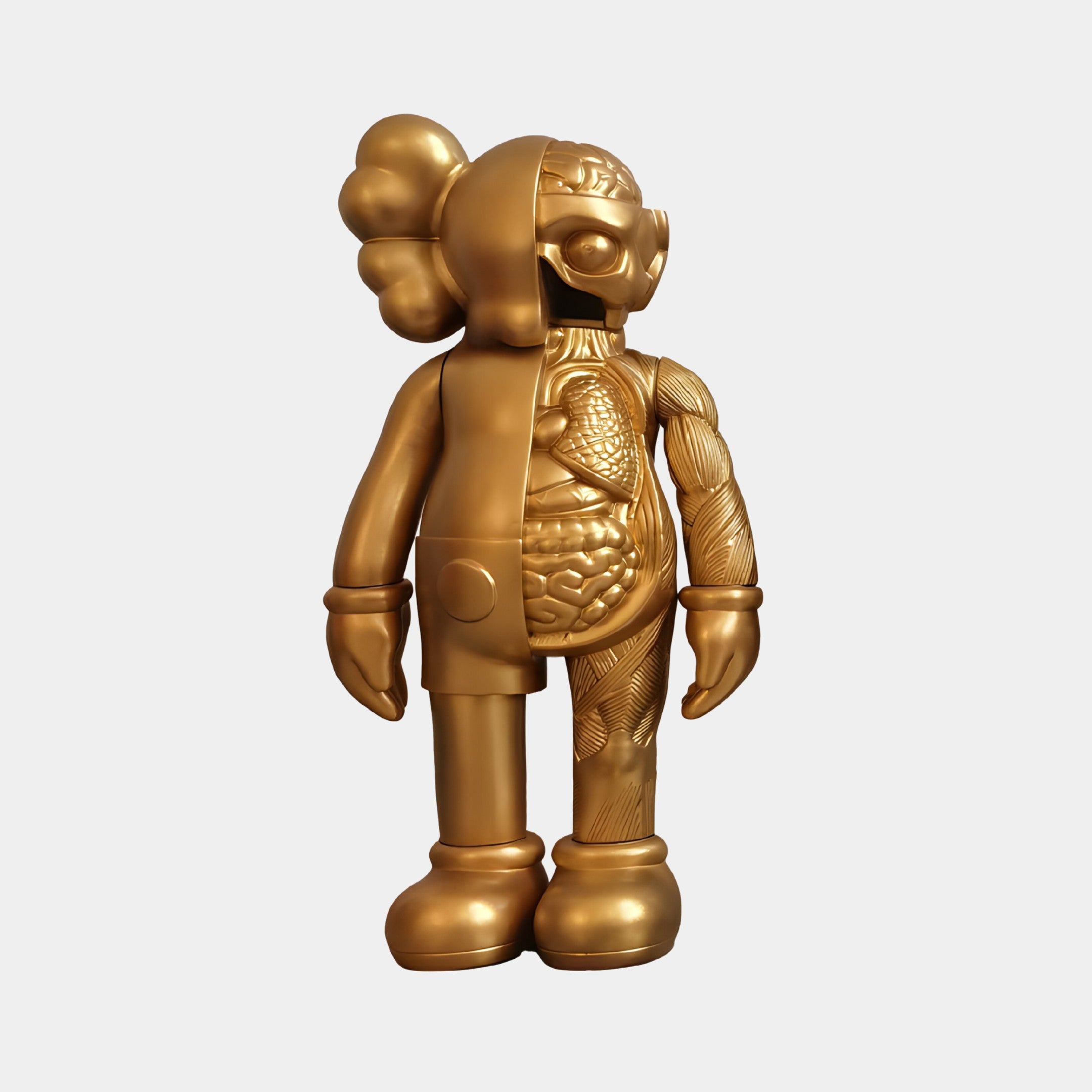 The Champagne Satin Gold Iconify Anatomy Figure by Giant Sculptures is a 37cm resin sculpture with cartoonish humanoid features on one side and intricate anatomical details on the other, standing upright with captivating exaggerated, rounded features.