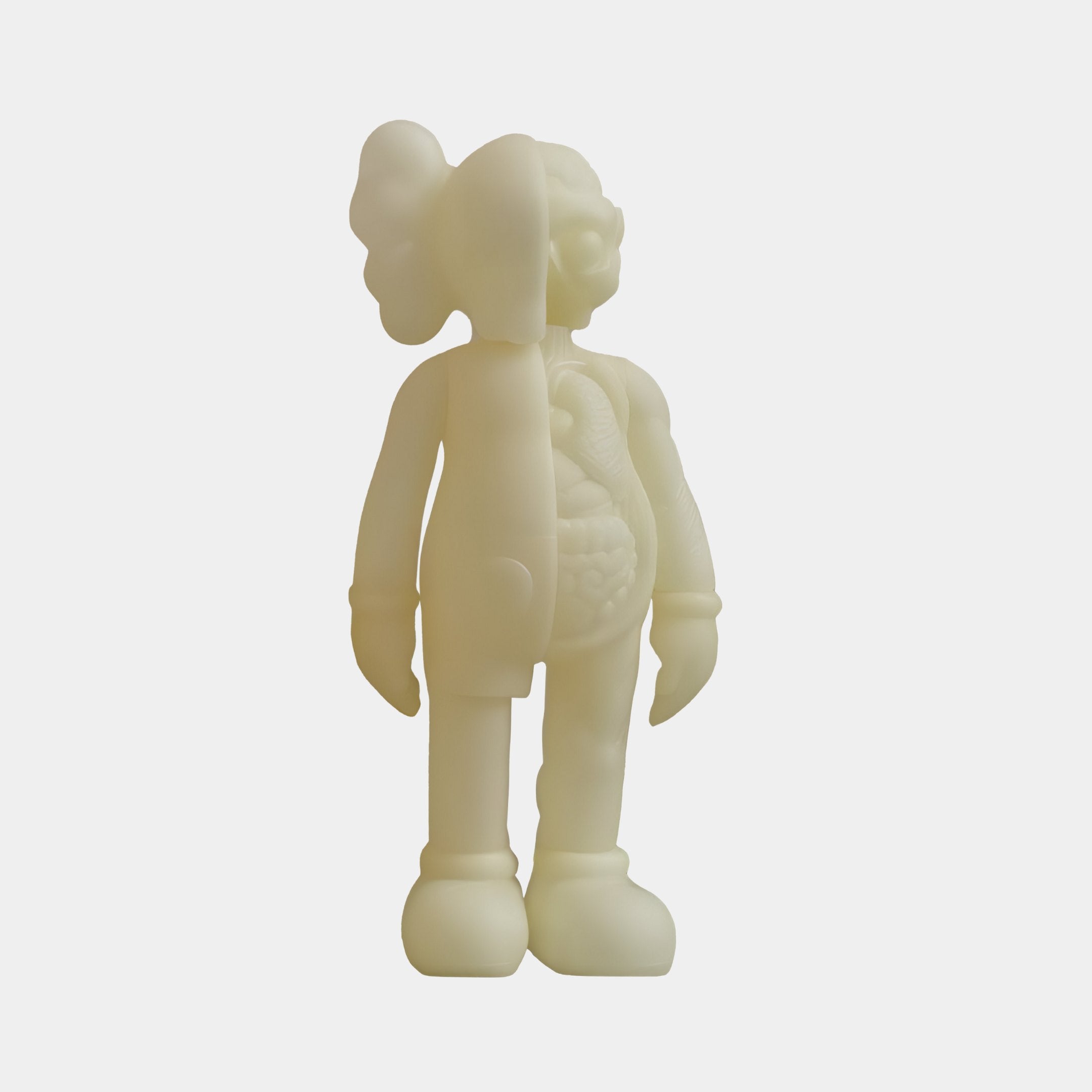 Meet the Ivory Iconify Anatomy Figure by Giant Sculptures: a 20cm glow-in-the-dark sculpture with a split design showing internal organs on one side. Featuring large shoes, gloved hands, and unique hair against a plain white backdrop, its an eye-catching addition to your decor.