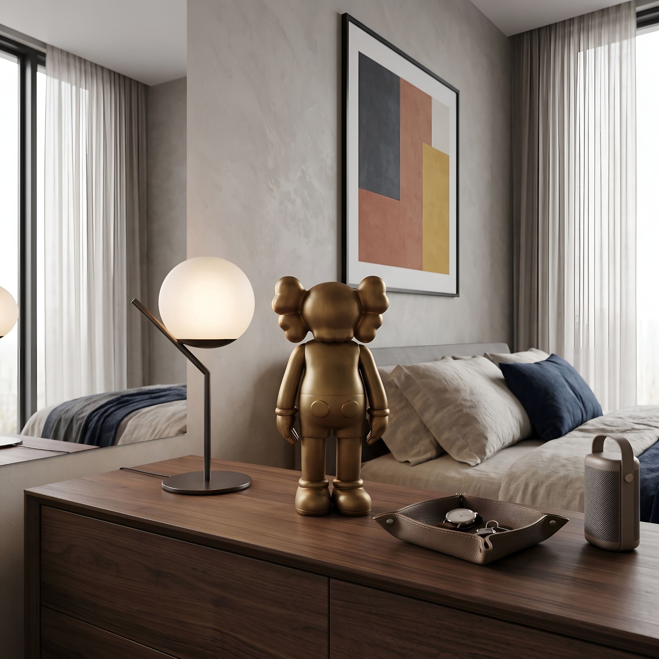 Antique Brushed Gold Iconify Standing Figure, 37cm, displayed on a wooden dresser in a bedroom beside a globe table lamp and framed abstract art.