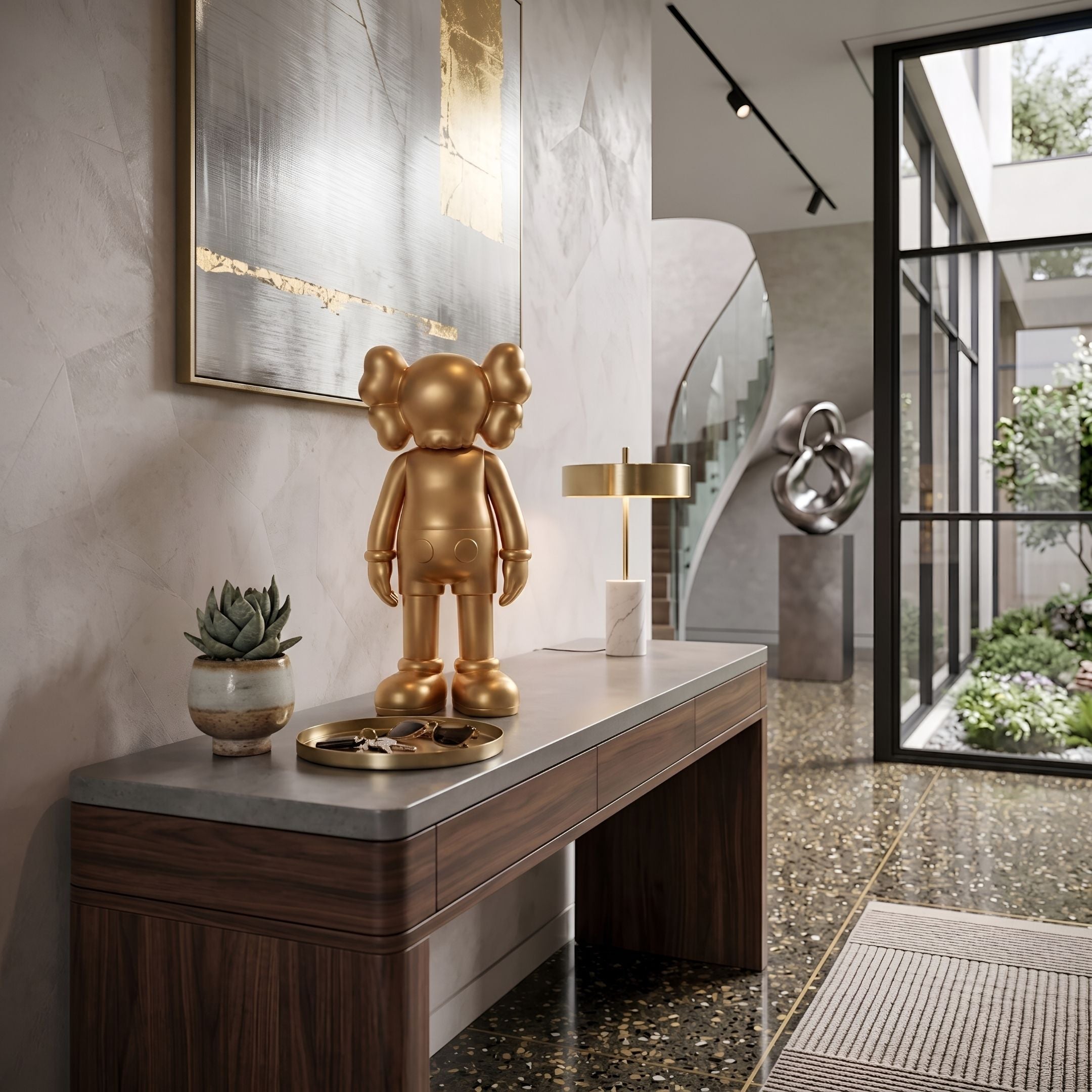 Champagne Satin Gold Iconify Standing Figure, 37cm, on a wood and stone console table beside a marble lamp and succulent in an entryway.