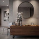Soft Grey Iconify Family Figure - 38cm, X-eyed parent figure holding two smaller figures, on a walnut sideboard beside vases, a clock, and a round mirror.
