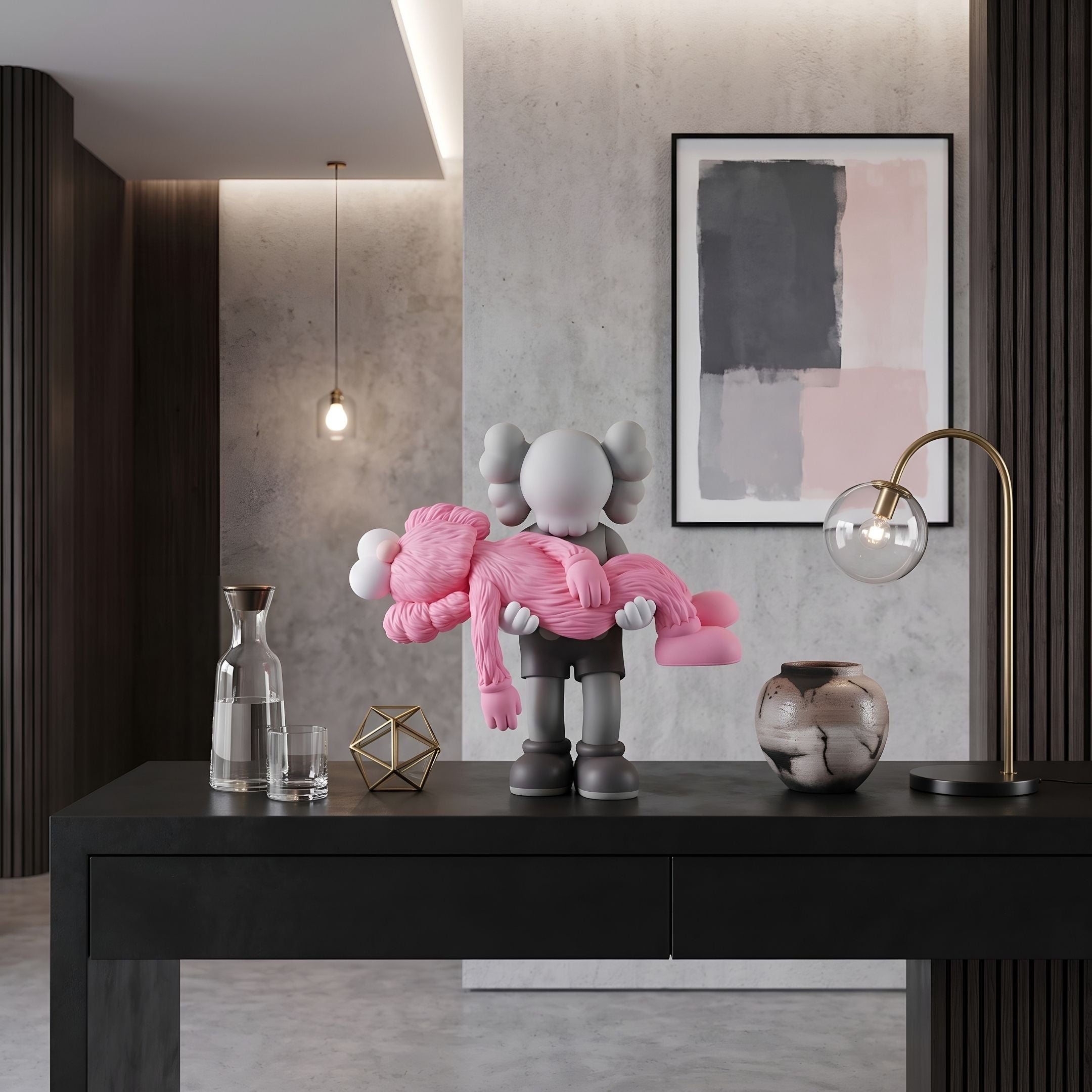 Petal Pink Iconify Rescuing Figure - 38cm, grey figure cradling a pink companion, displayed on a black console table beside a gallery wall and gold-toned lamp.